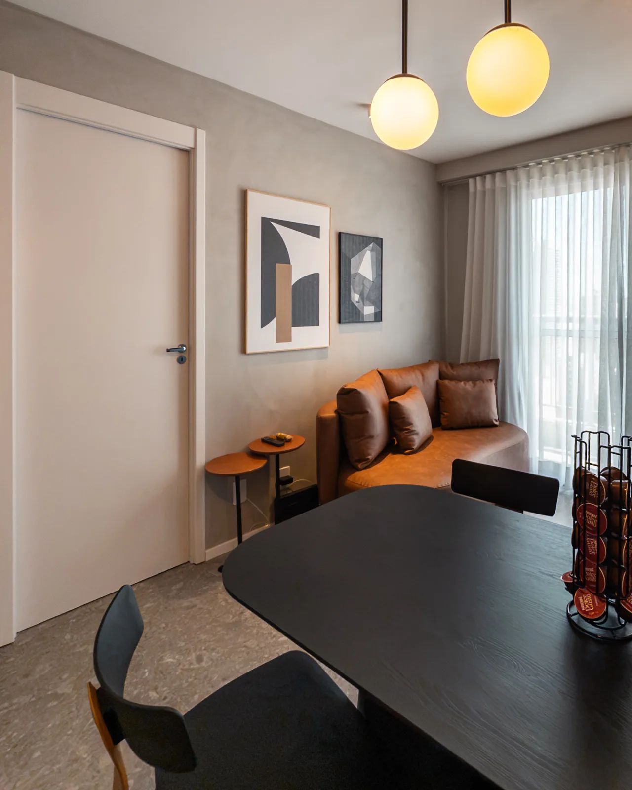 Sala de estar com sofá de couro e quadros decorativos
