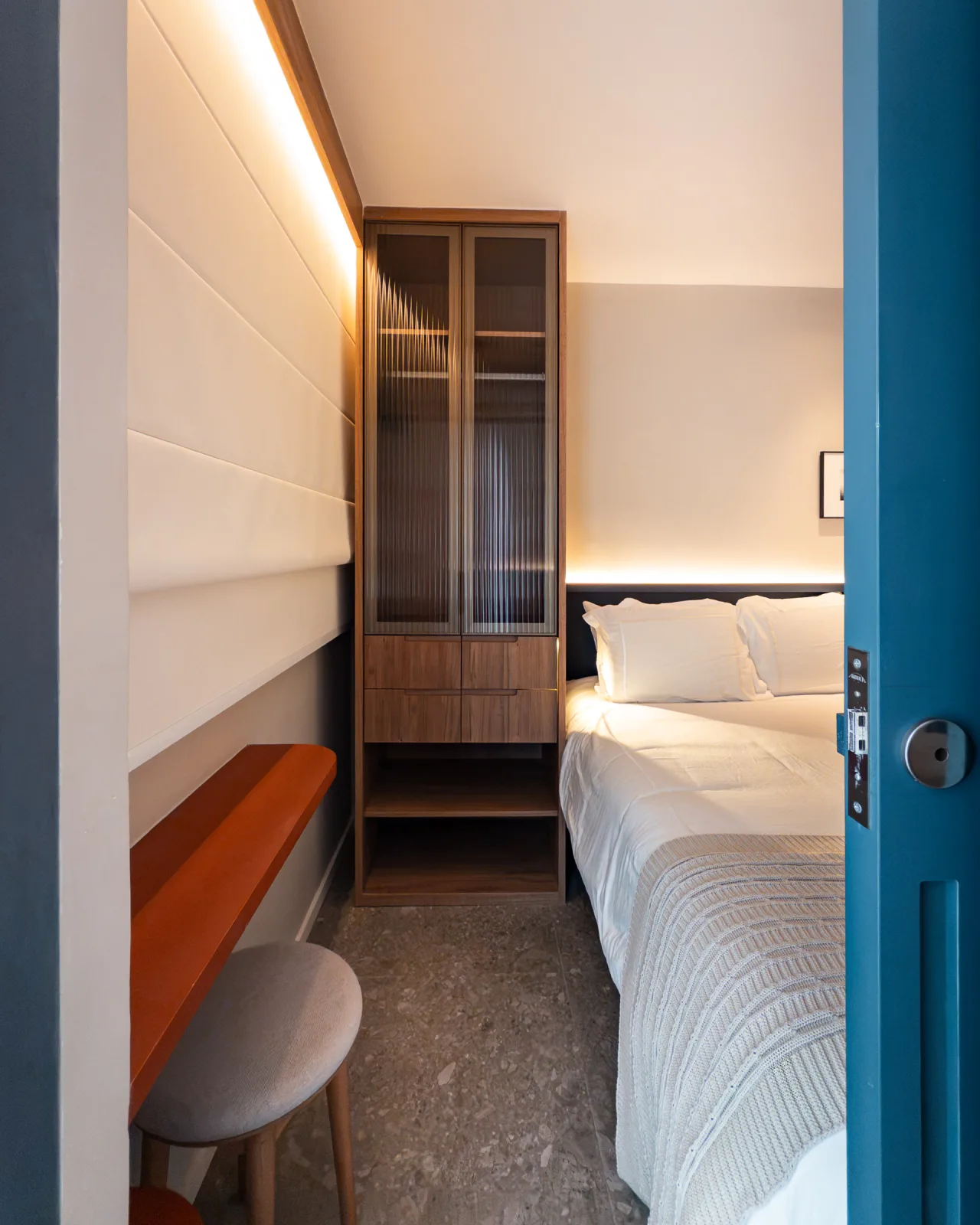 Quarto com cama de casal, cristaleira envidraçada e escrivaninha
