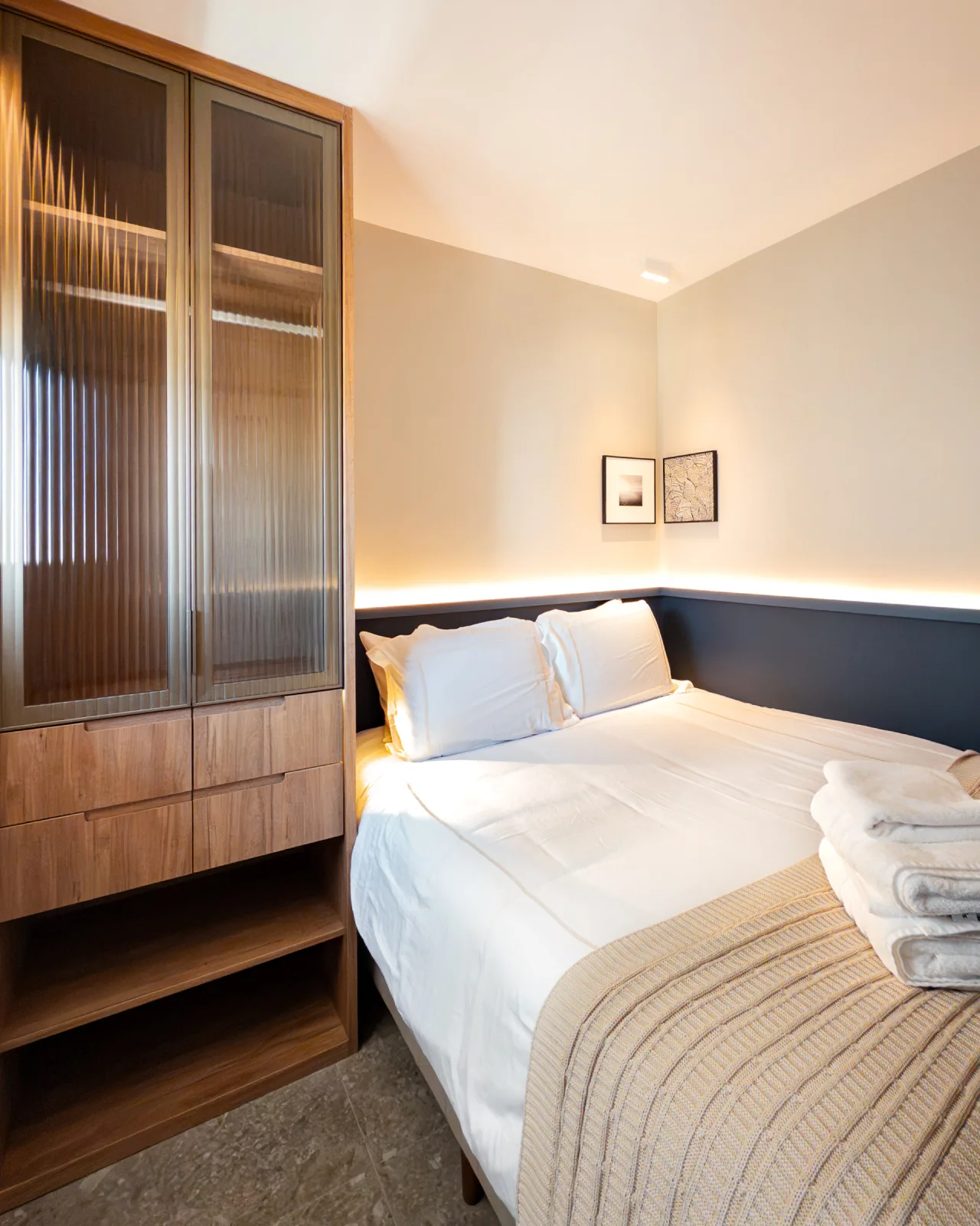 Quarto com cama de casal e closet com portas de vidro