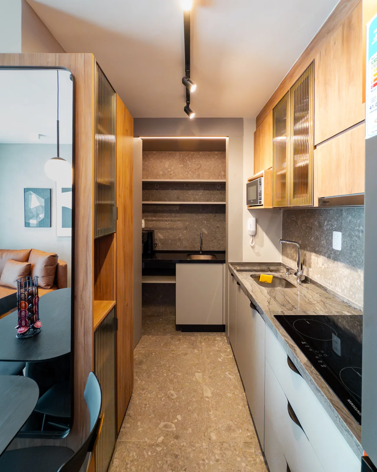 Cozinha corredor com despensa, bancada em granito e cooktop